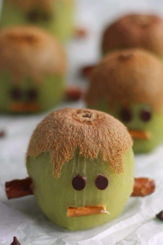 Healthy Halloween Party Snacks - Frankenstein Kiwis - Healthy Ideas for Kids for School, Teens and Adults - Easy and Quick Recipes and Idea for Dips, Chips, Spooky Cookies and Treats - Appetizers and Finger Foods Made With Vegetables, No Candy, Cheap Food, Scary DIY Party Foods With Step by Step Tutorials #halloween #halloweenrecipes #halloweenparty