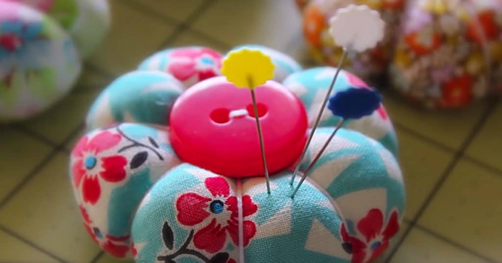 Learn to sew this DIY quilted petal pincushion with a small piece of fabric and a button