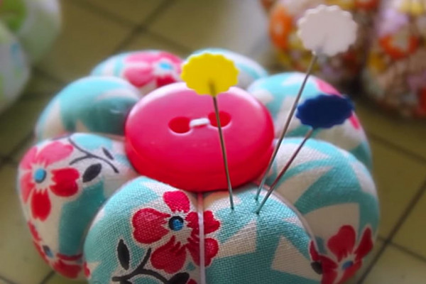 Learn to sew this DIY quilted petal pincushion with a small piece of fabric and a button