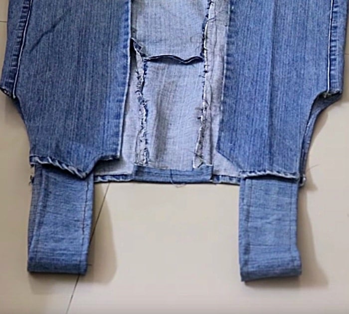 Make a long denim woman's vest out of a large pair of men's jeans
