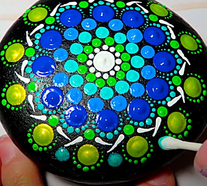 Paint mandala dots with a q tip on a stone