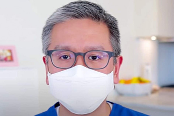Medical Doctor makes a paper face mask with a stapler and rubber bands