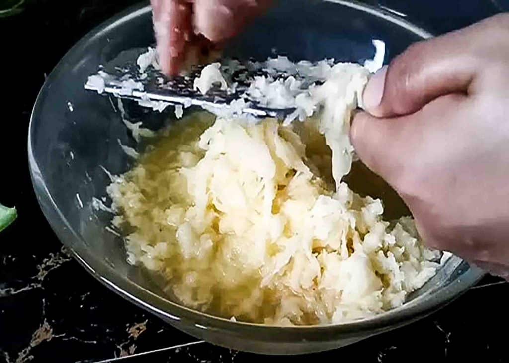 Grating the potatoes for the potato pancake recipe