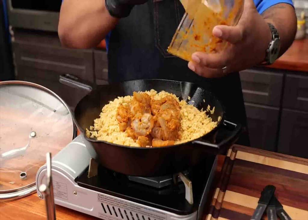 Adding the cajun shrimp into the rice skillet
