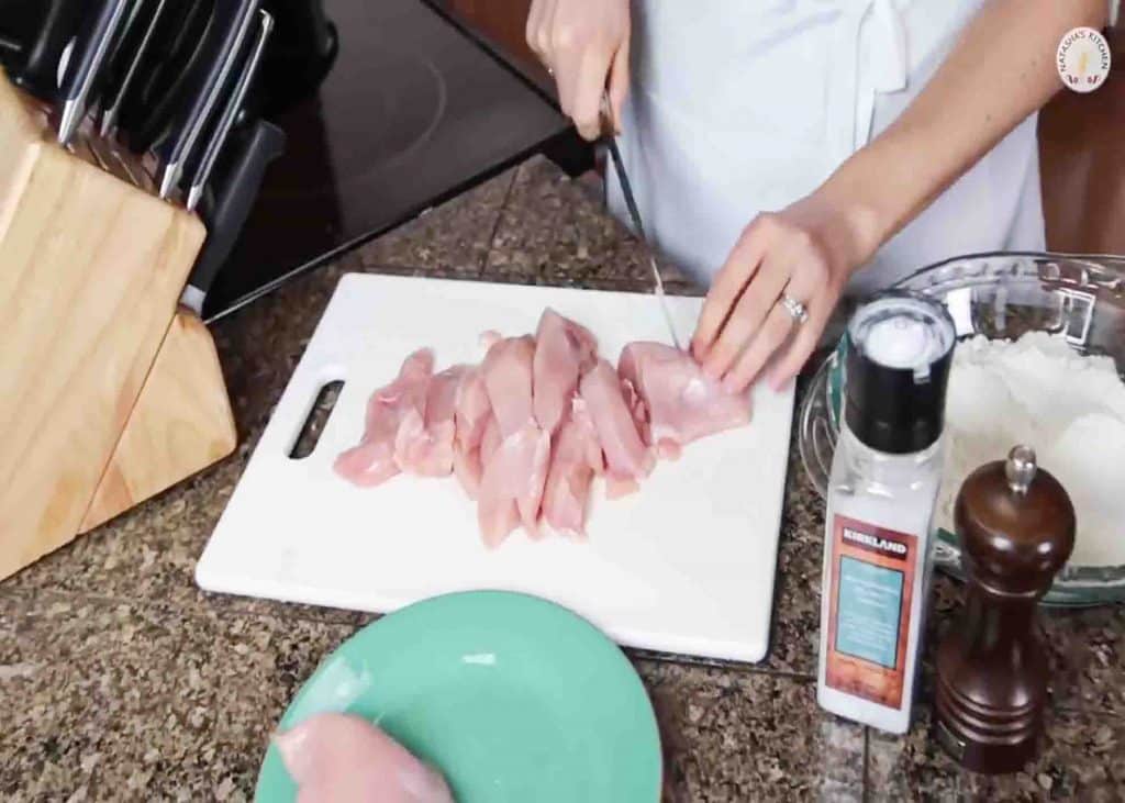 Cutting the chicken breasts into strips