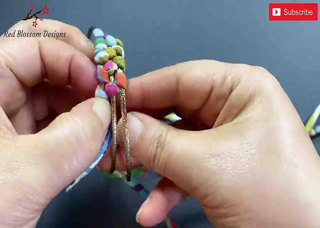 Braiding the fabric string into the metal wristbands
