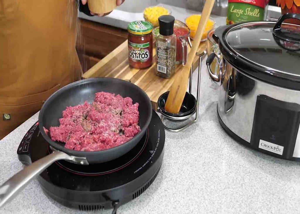 Cooking the lean ground beef and seasoning it with salt
