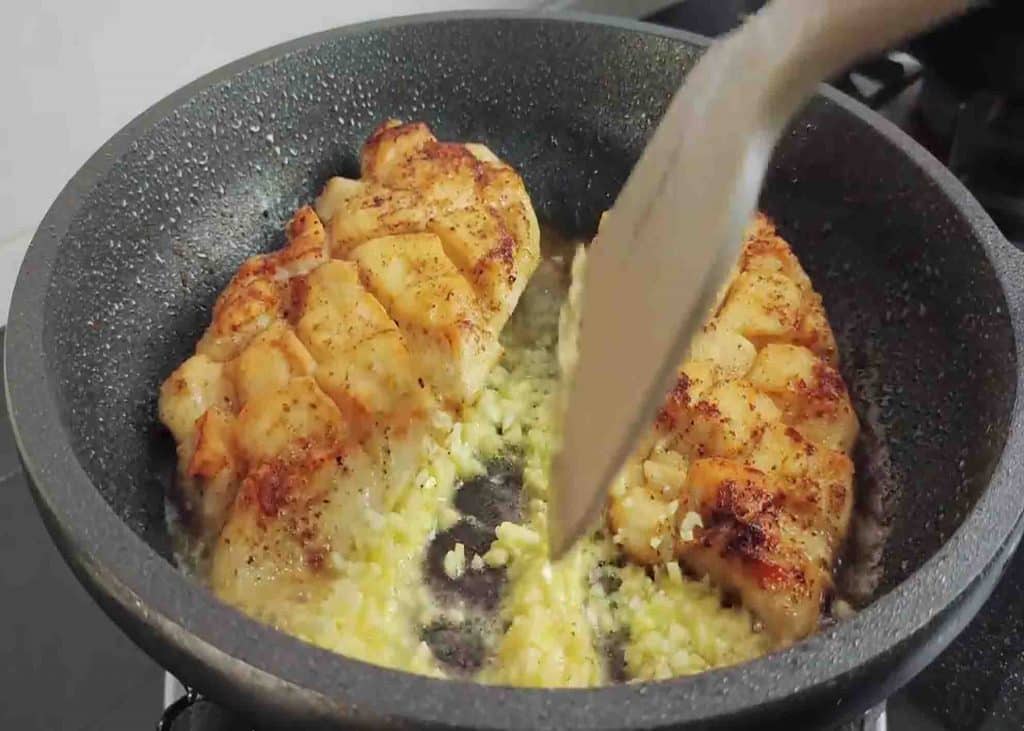 Sauteeing the minced arlic alongside the chicken breasts