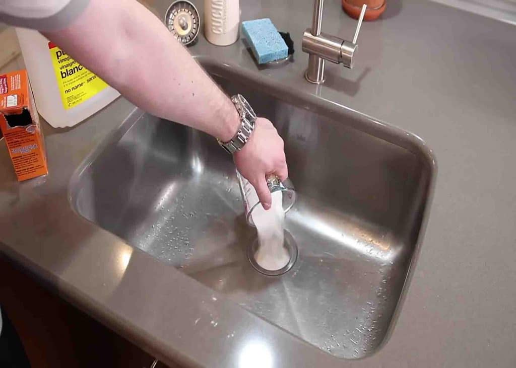 Pouring baking soda to the sink drain