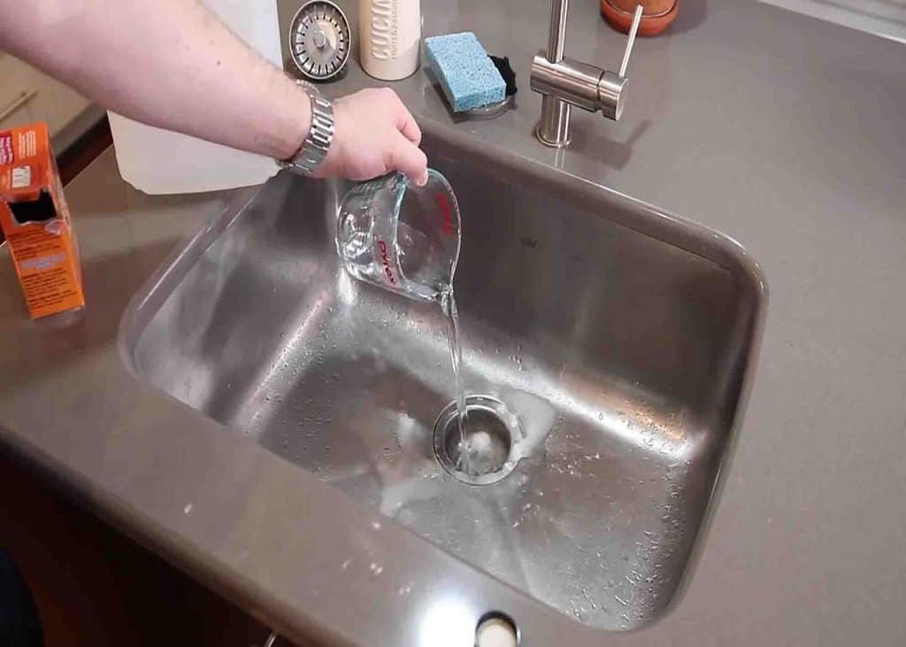 Pouring vinegar down the sink drain