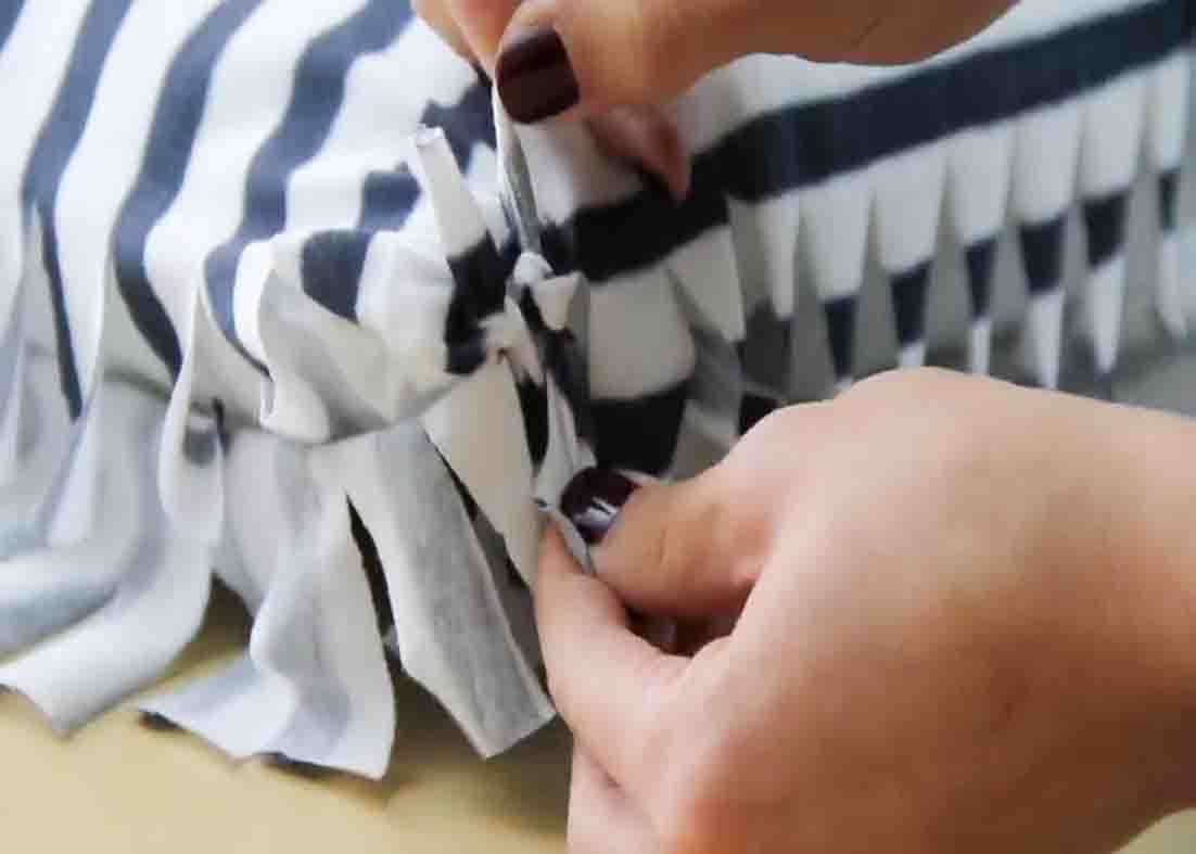 Tying the strips to form the pillow case