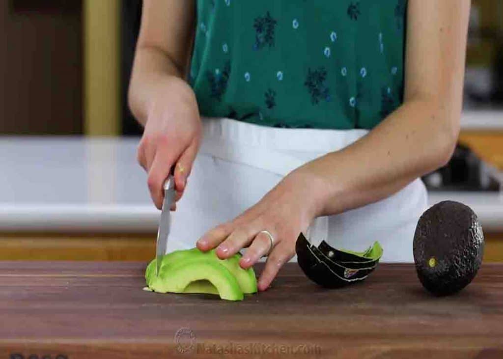 Slicing the avocado into bite-size pieces