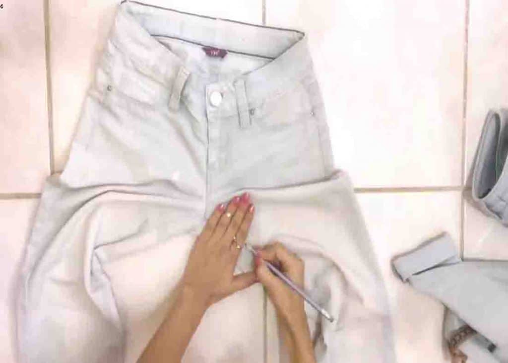 Measuring the crotch area of the jeans that will be cut