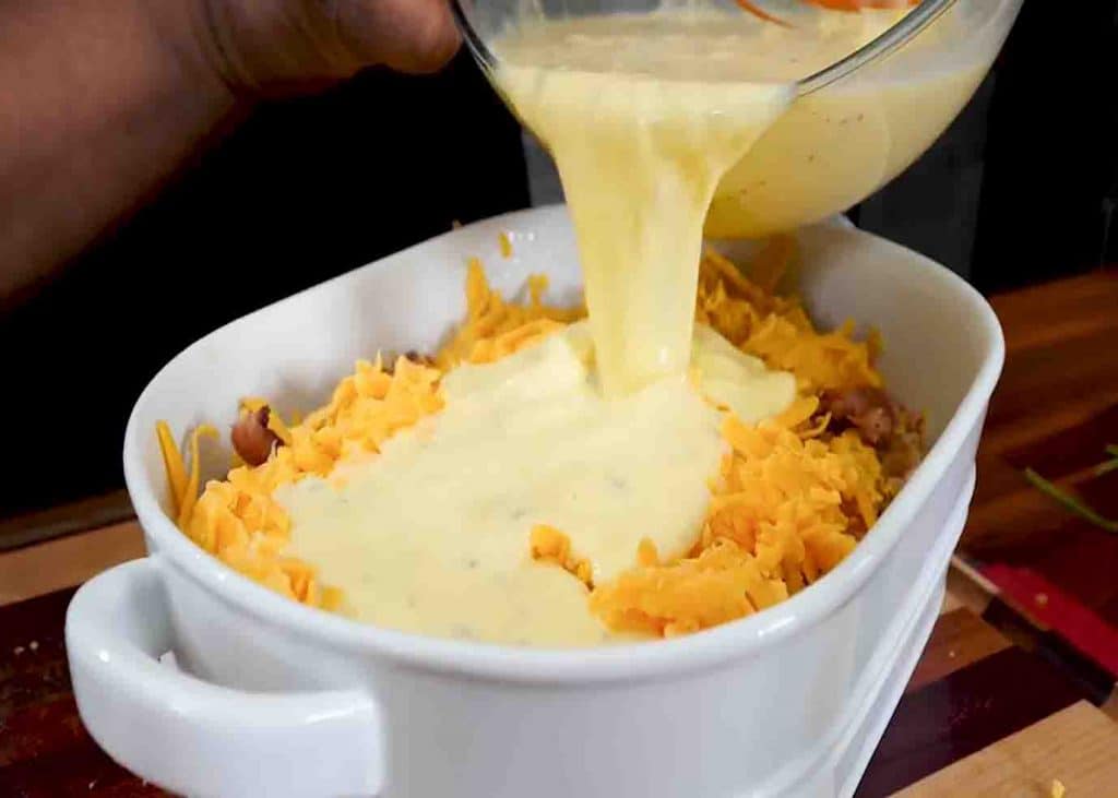 Pouring the egg and milk mixture into the casserole