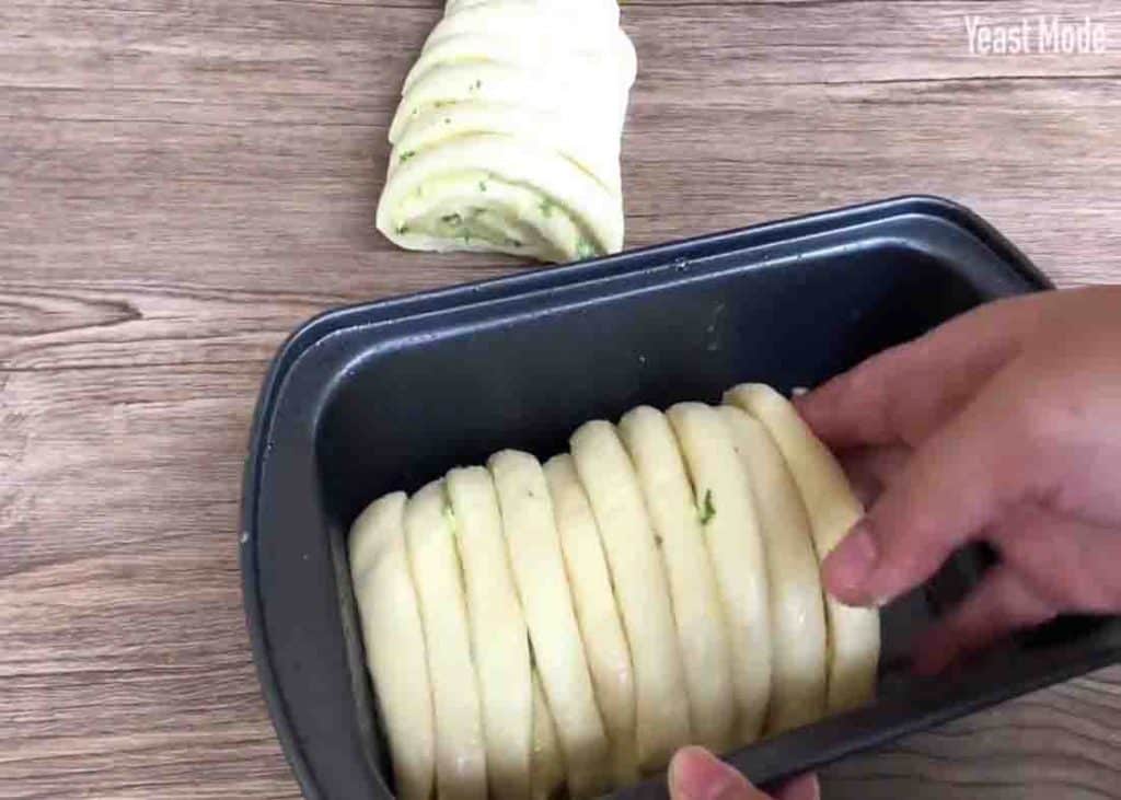 Placing the sliced dough to the loaf pan