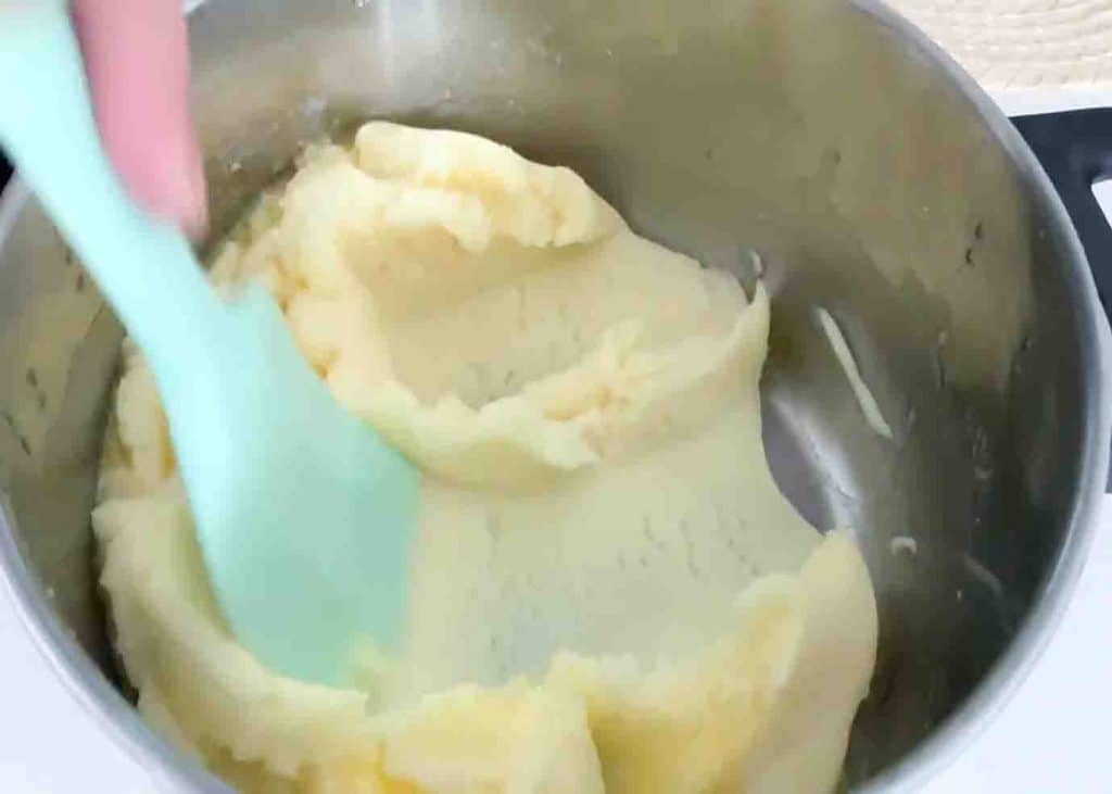 Mixing the mashed potato with butter and milk