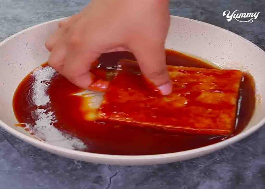 Dipping the slice of bread to the butterscotch sauce