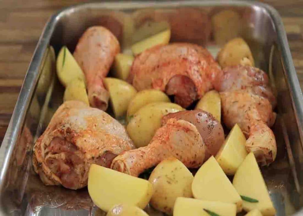 Assembling all the roasted chicken and potatoes ingredients into the tray