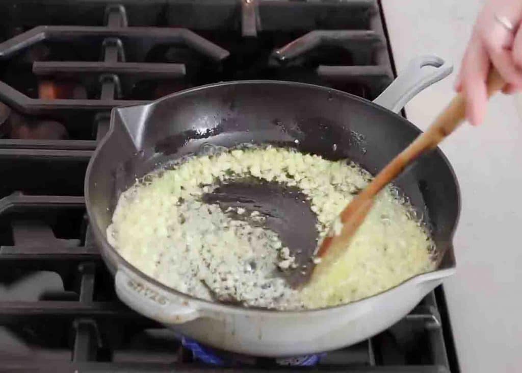 Sauteeing the minced garlic in butter and olive oil
