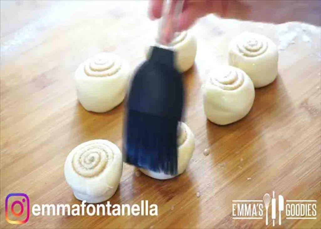 Brushing the cinnamon rolls with some milk