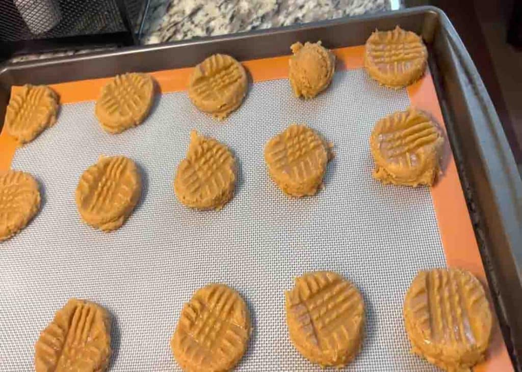 Adding the peanut butter cookies to the baking sheet