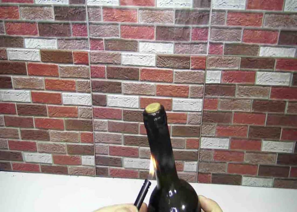 Heat the neck of the wine bottle using a lighter to pop the screw out