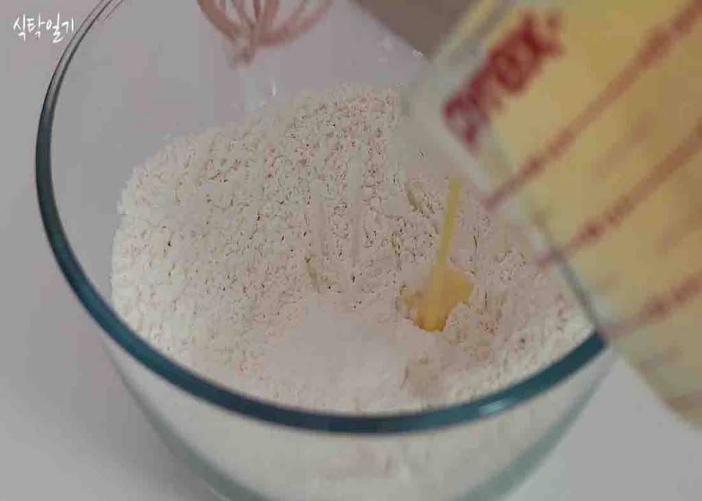 Pouring over the beaten eggs into the flour