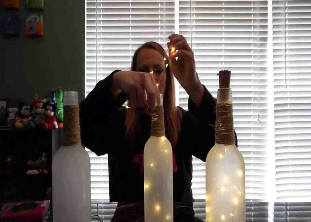 Putting the wine bottle lights inside the frosted bottles