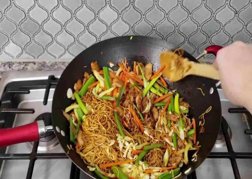Mixing the chow mein before serving