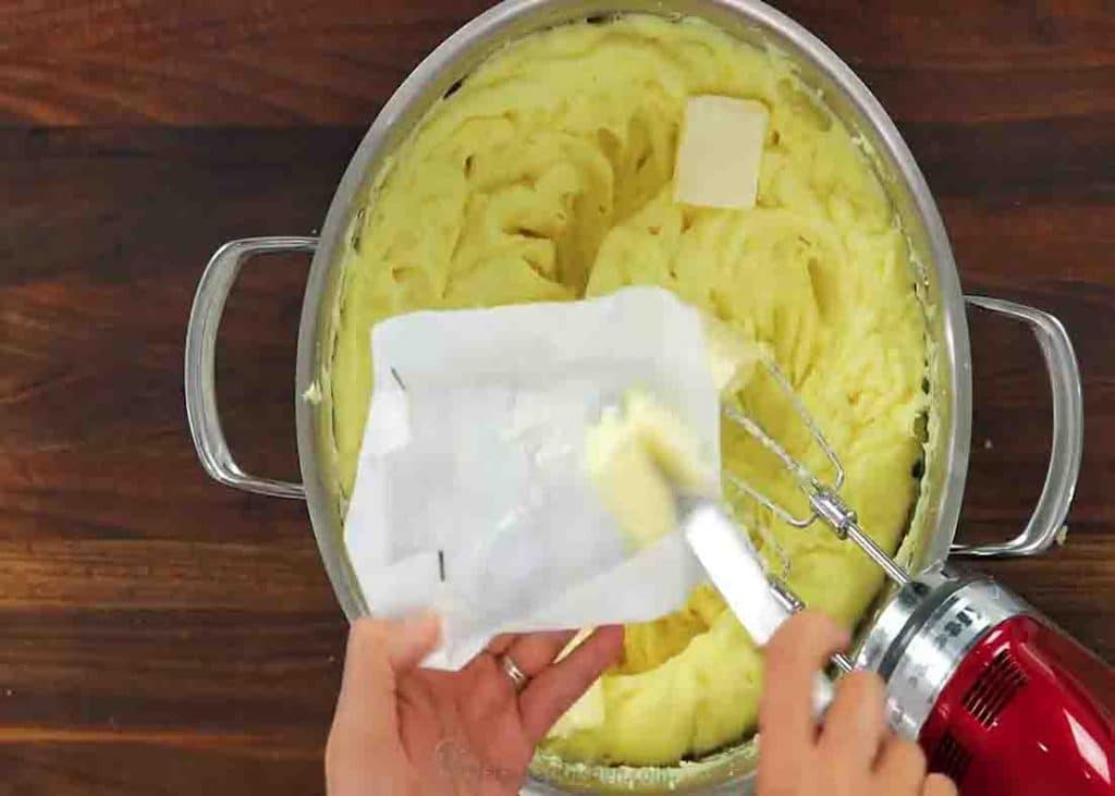 Adding butter over the top of mashed potatoes