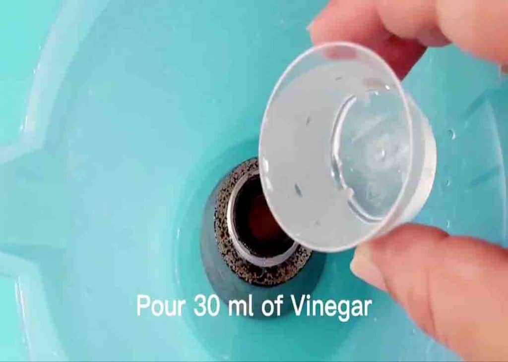 Pouring some vinegar over the clogged shower head