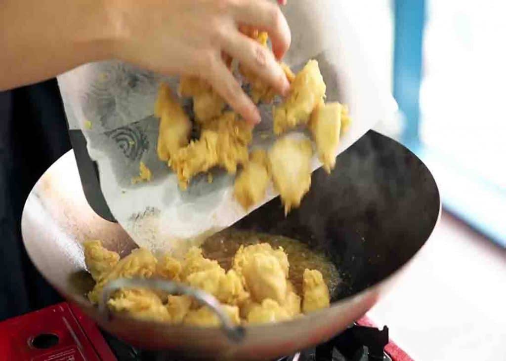 Adding the chicken to the lemon sauce