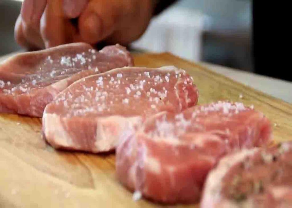 Seasoning the pork chops with some salt and pepper