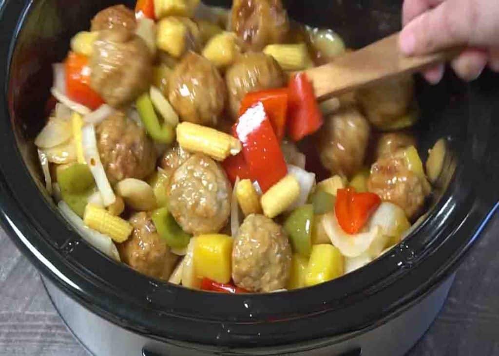 Mixing the sweet and sour meatballs before serving