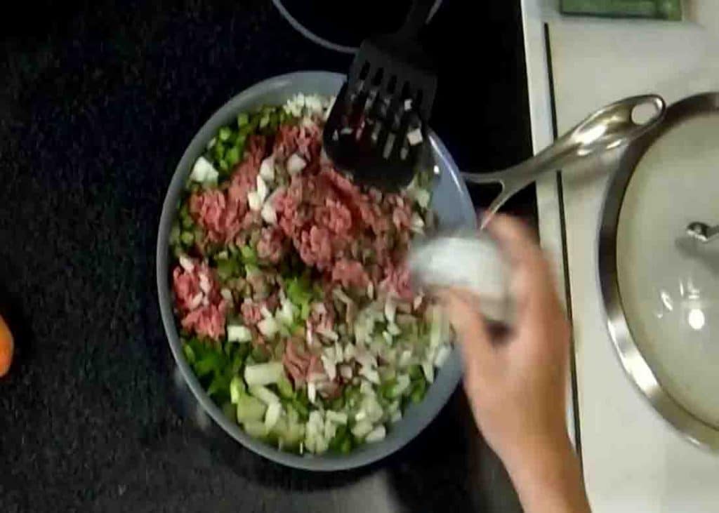 Adding all the hamburger casserole ingredients to the pan