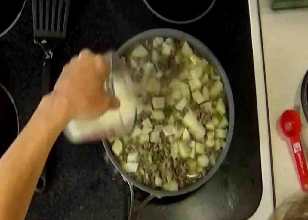 Adding the milk to the hamburger casserole before putting it to the oven