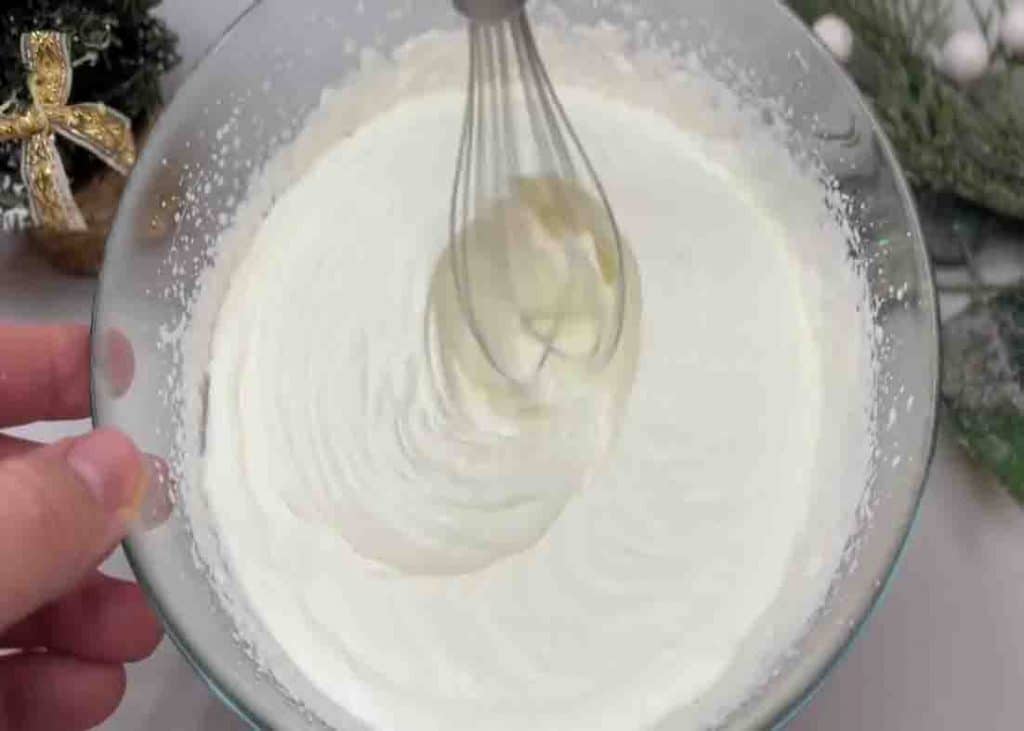 Whisking the whipped cream and condensed milk to make ice cream
