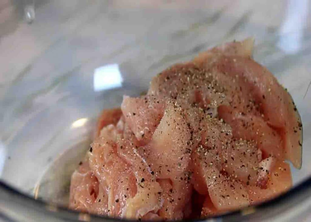 Seasoning the chicken breasts with some salt and pepper for the pineapple chicken recipe