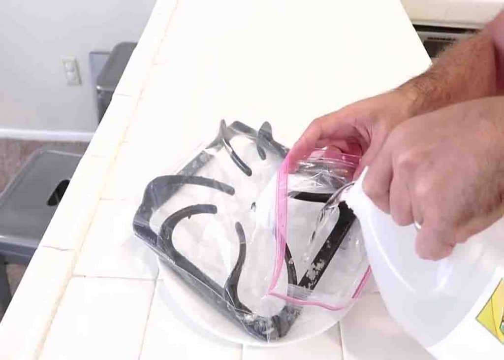 Pour vinegar or ammonia to the ziplock with the stovetop piece