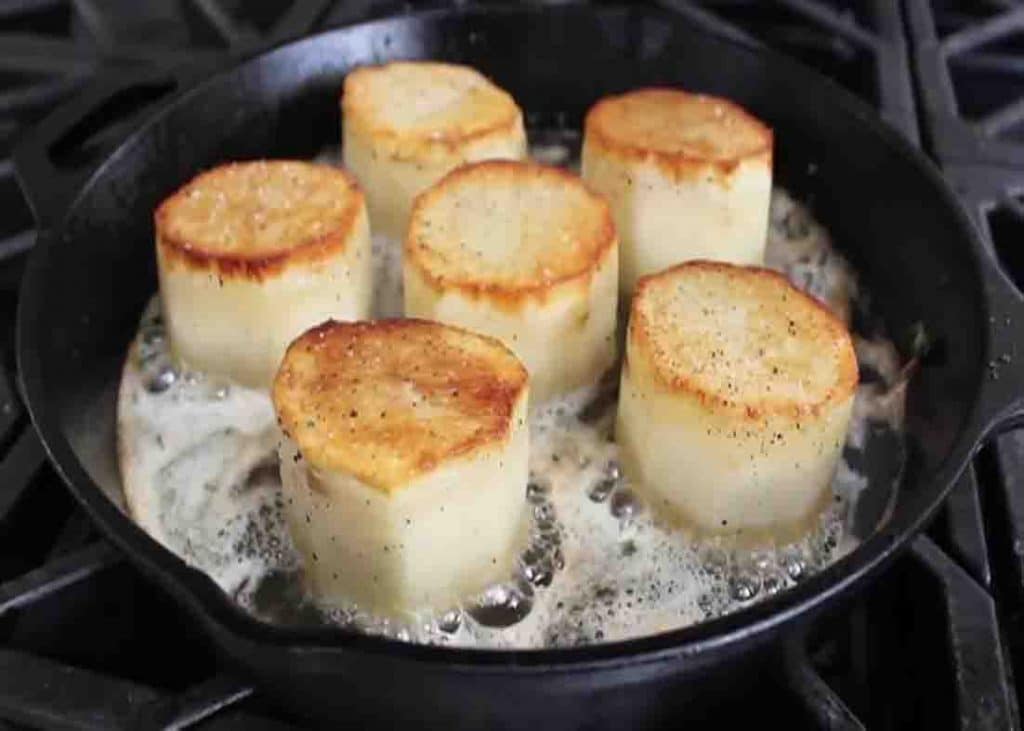 Simmering the potatoes in butter