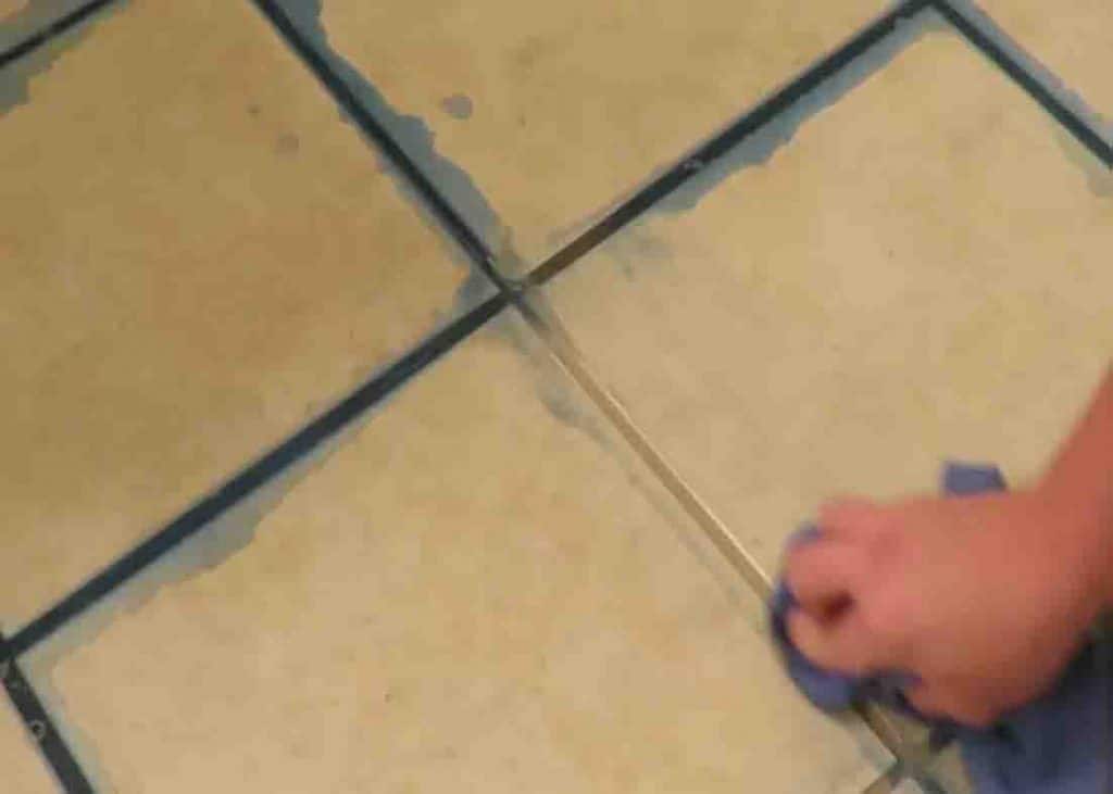 Wiping off the cleaning solution on the grout