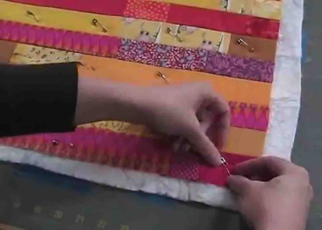 Pinning the layers of the quilt sandwich with safety pins to keep it in place