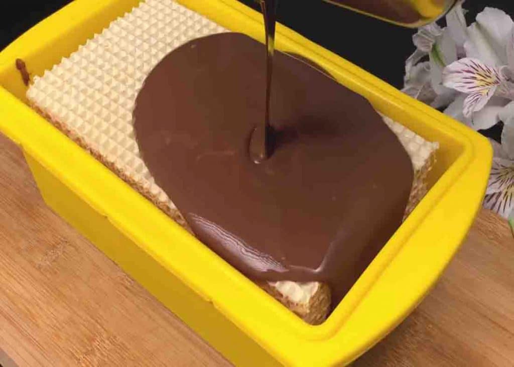 Pouring the chocolate over the kitkat cake