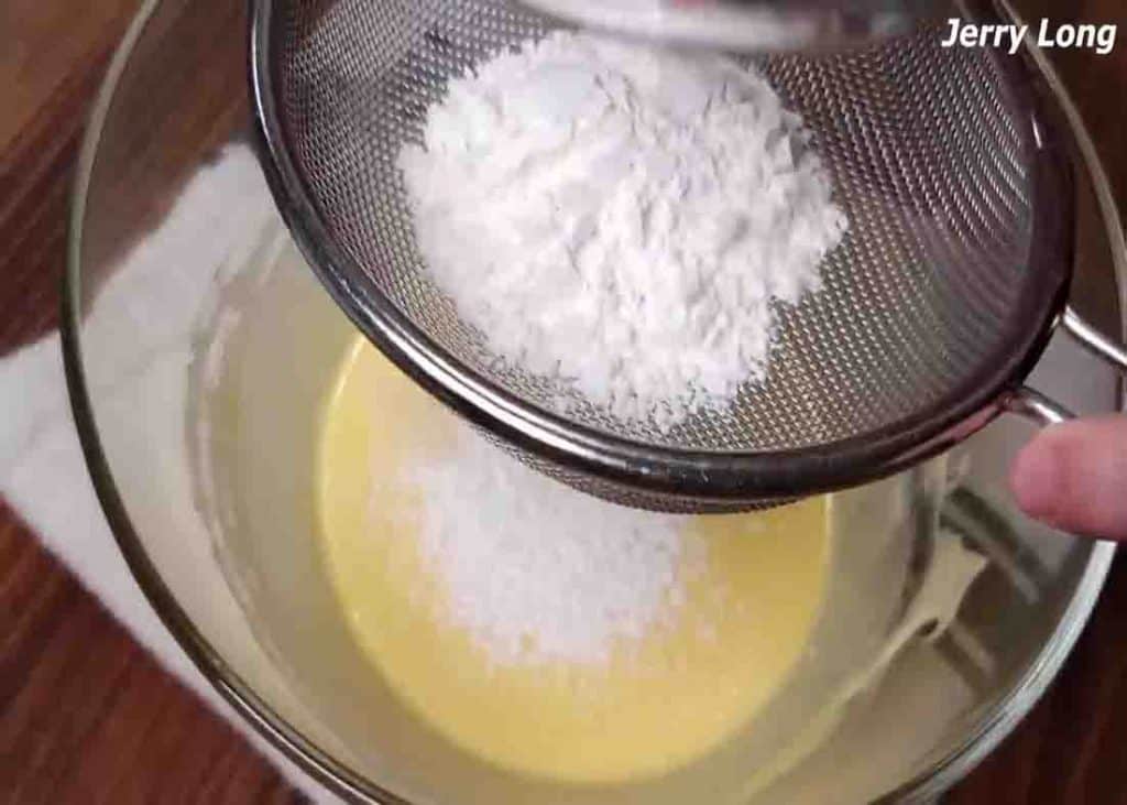 Sifting the cake flour to the egg yolks mixture