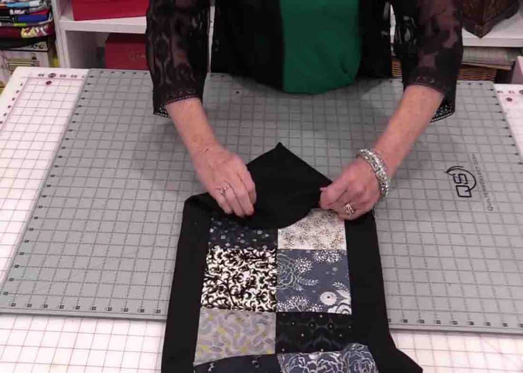 Flipping the pointy fabric of the quilted table runner on the right side