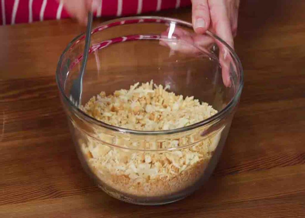 Mixing the crackers with butter for the topping of the squash casserole