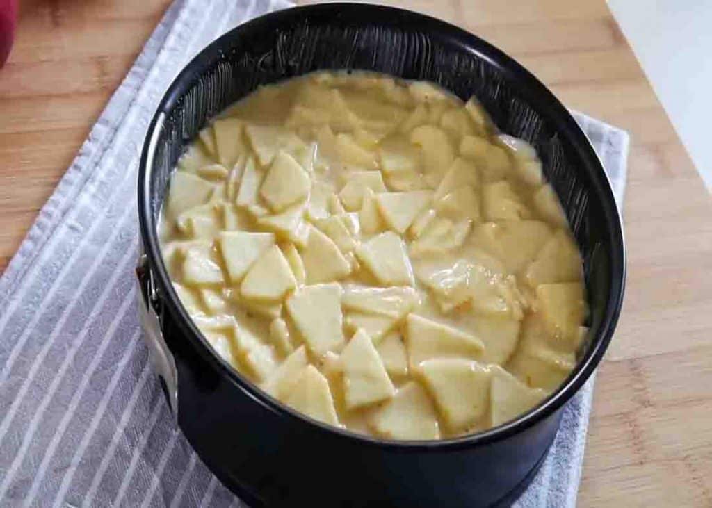 Pouring the apple cake batter to the greased pan