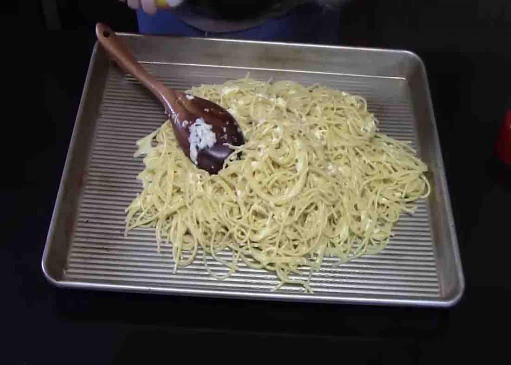 Spreading the spaghetti noodles to the baking tray