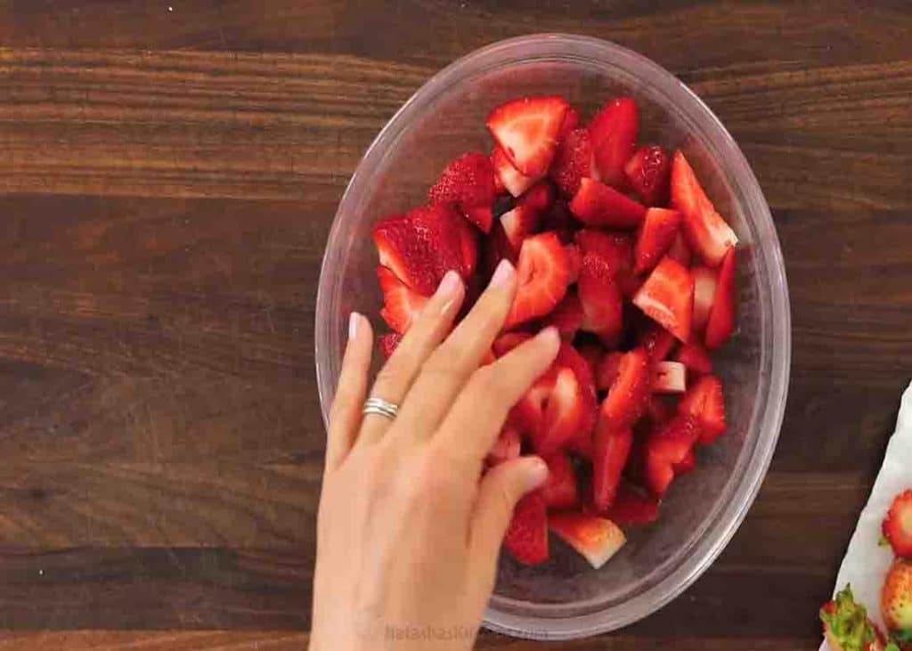 Slicing the strawberries into quarters for the eton mess recipe