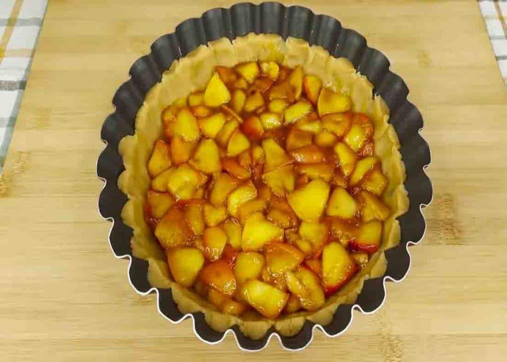 Adding the apple filling beneath the apple pie